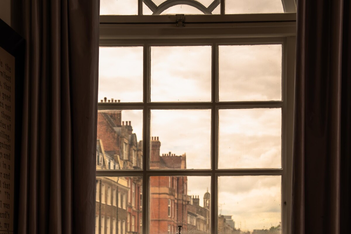 A room with a large window overlooking a city street.