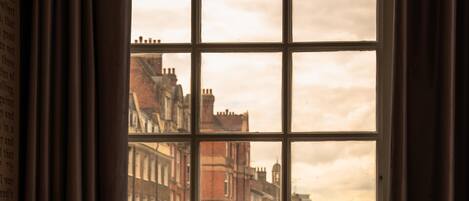 A room with a large window overlooking a city street.