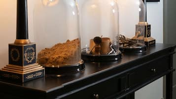 A dark wooden console table with three lamps and two glass domes containing decorative items.