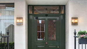 A green double door with a small dog statue in front. - Holmes Hotel London (London)