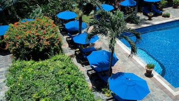 Een buitenzwembad, parasols voor strand/zwembad