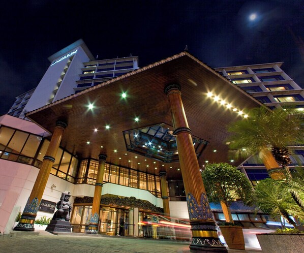 A hotel with a modern facade, large columns, and a prominent entrance with glass doors.