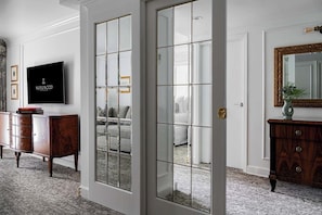 A room with a large mirror, a television, and a wooden cabinet. - Wedgewood Hotel & Spa (Vancouver)