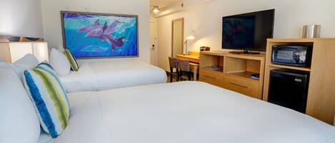 Habitación de hotel con dos camas, un escritorio, un televisor y un refrigerador.