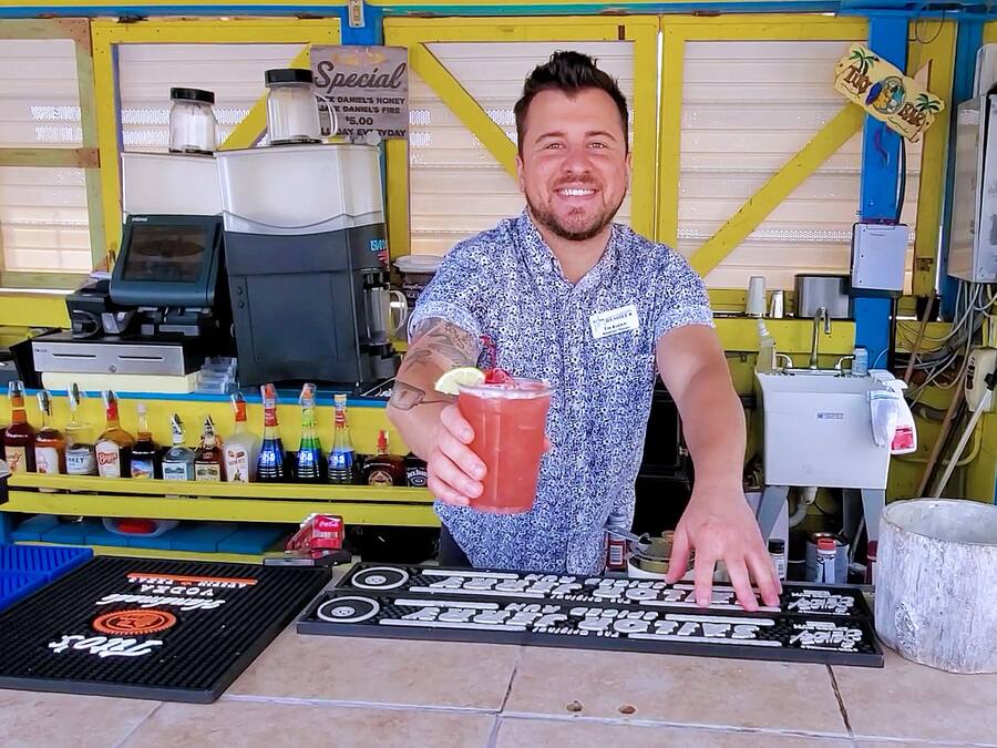A bar area with a counter, various bottles, and a sign indicating a special offer.