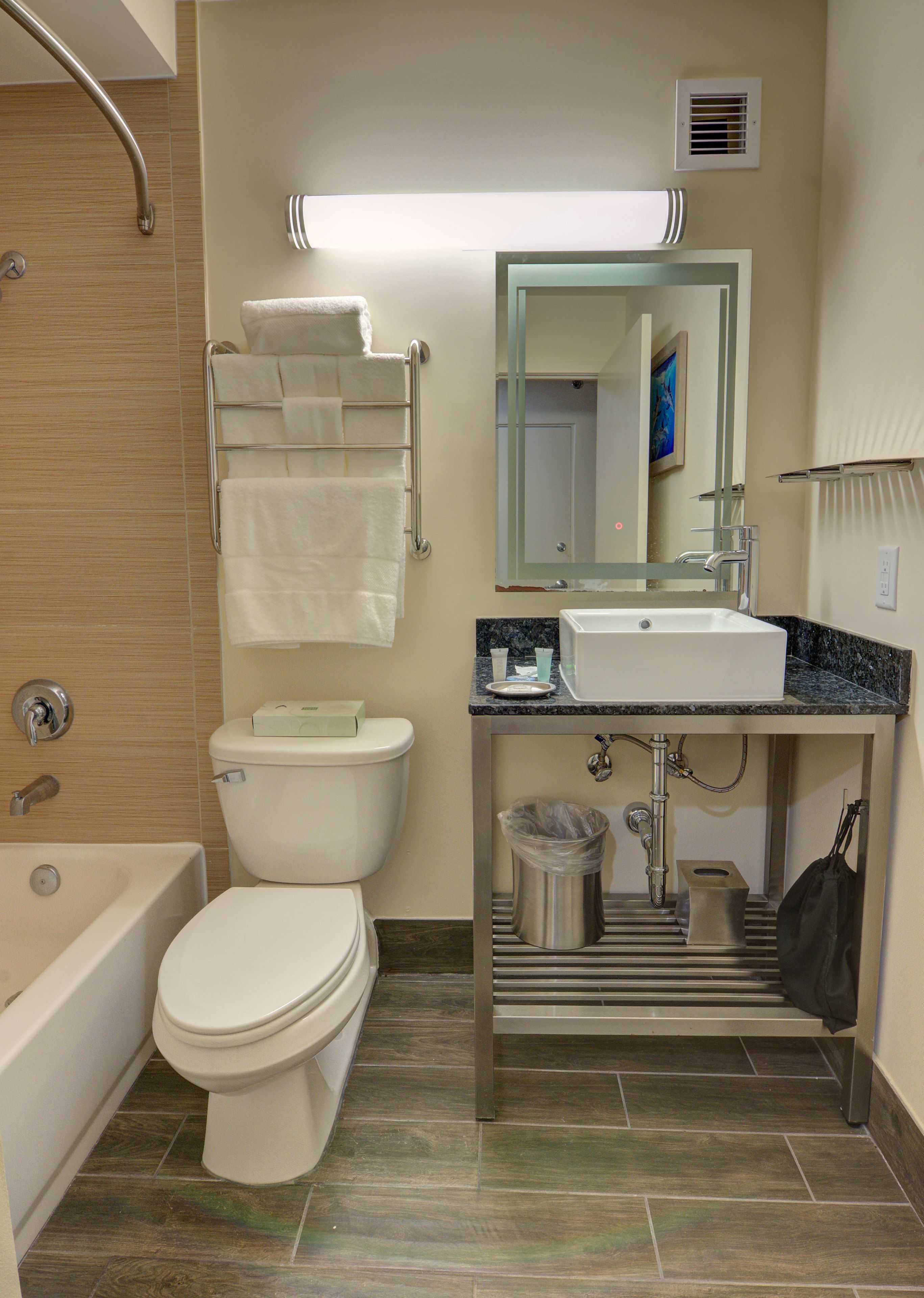 A modern bathroom with a toilet, sink, and bathtub.