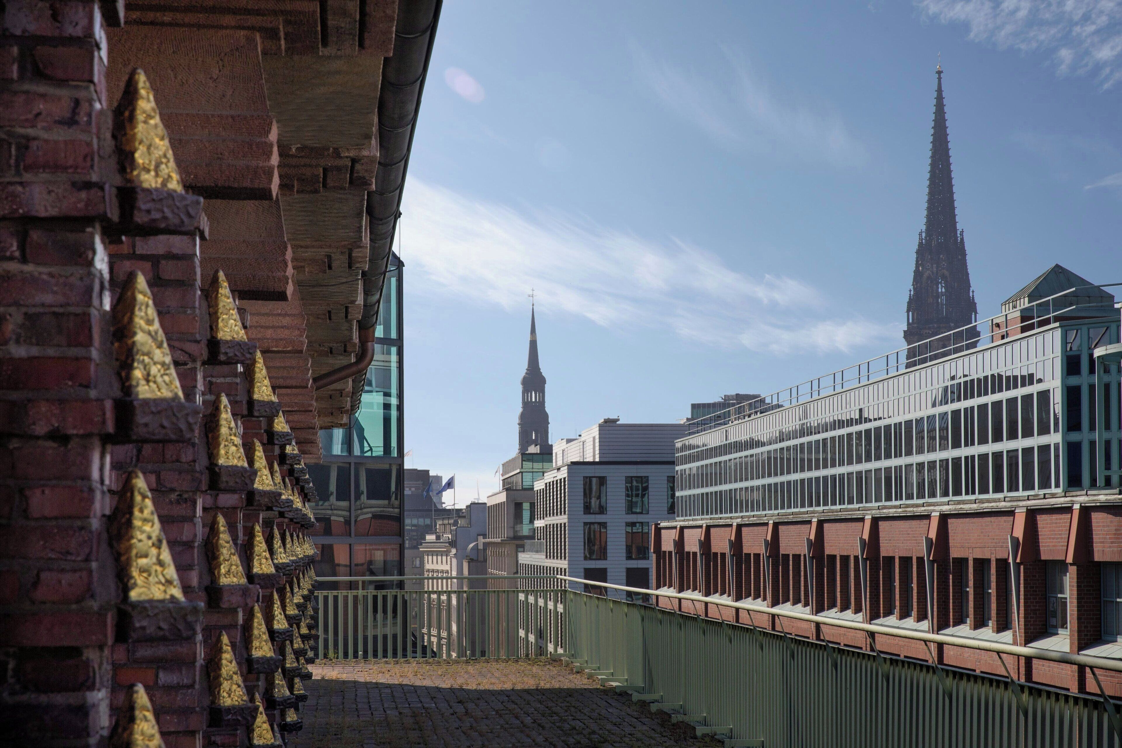 Vista de un paisaje urbano con una imponente aguja de iglesia y edificios modernos.