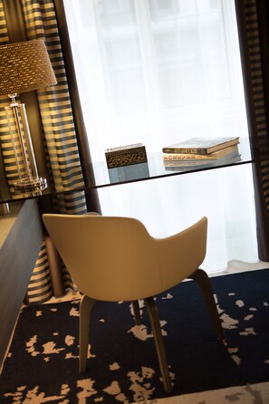 Relax in a stylish space with a glass-top side table, comfortable chair, and floor lamp.
