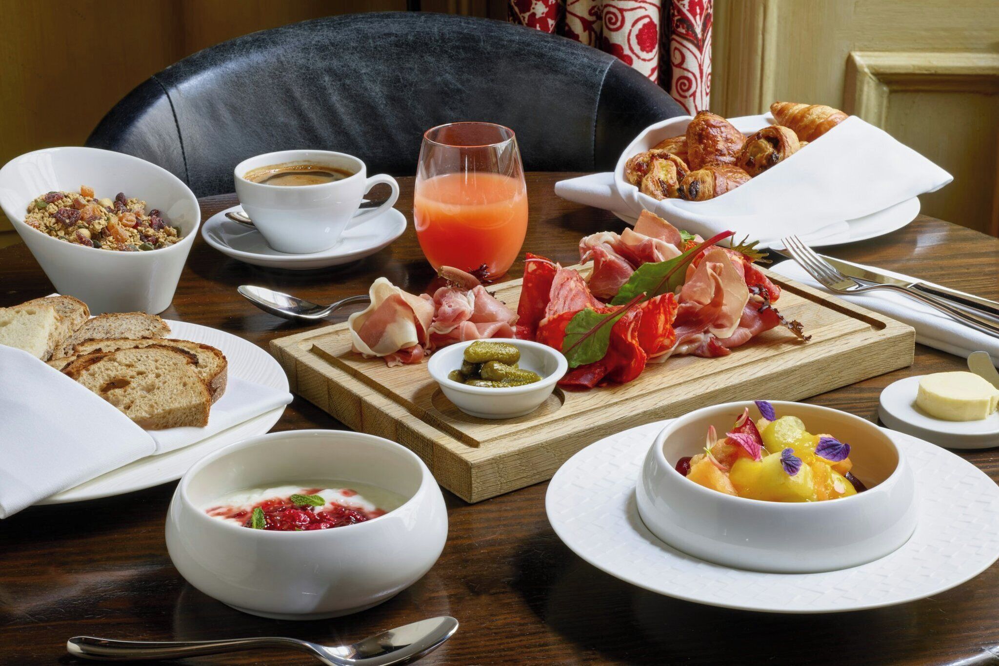 Une table mise pour le petit-déjeuner, avec divers aliments et une tasse de café.