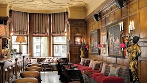 A traditional interior with a bar area, seating, and a statue. - The Gore London – Starhotels Collezione (London)