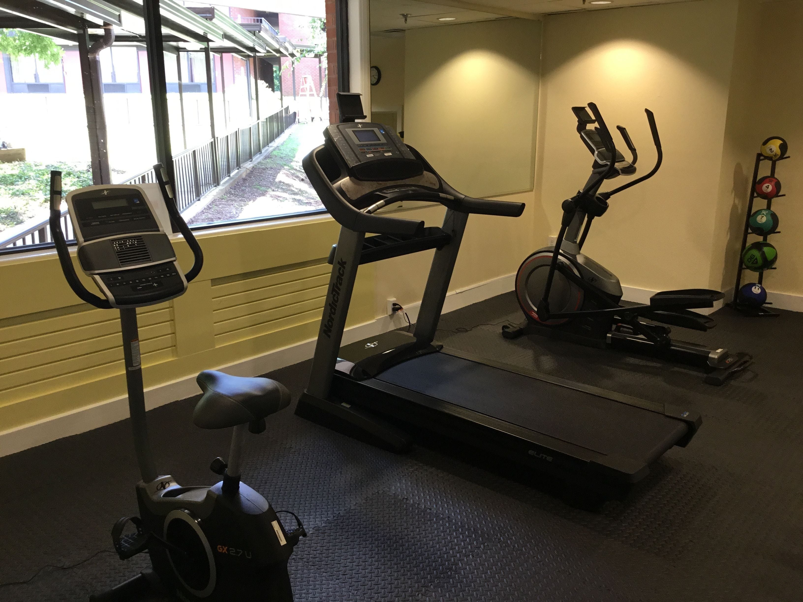 A gym with treadmills, an elliptical, and a stationary bike.