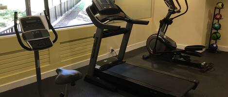 A gym with treadmills, an elliptical, and a stationary bike.