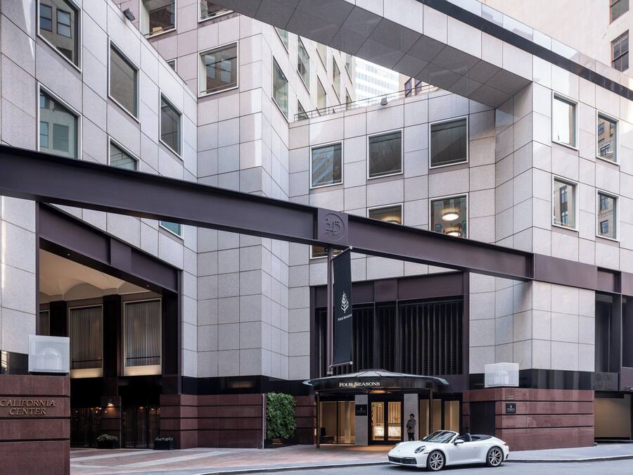 A modern hotel entrance with a prominent sign for "California Center" and "Porte Seasons."