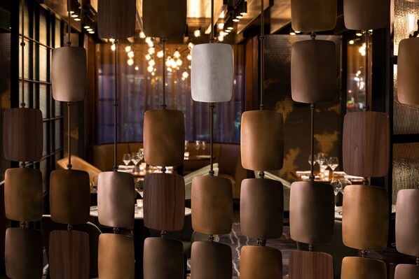 A restaurant interior with hanging pendant lights and a view of the dining area. - Four Seasons Hotel San Francisco at Embarcadero (San Francisco)