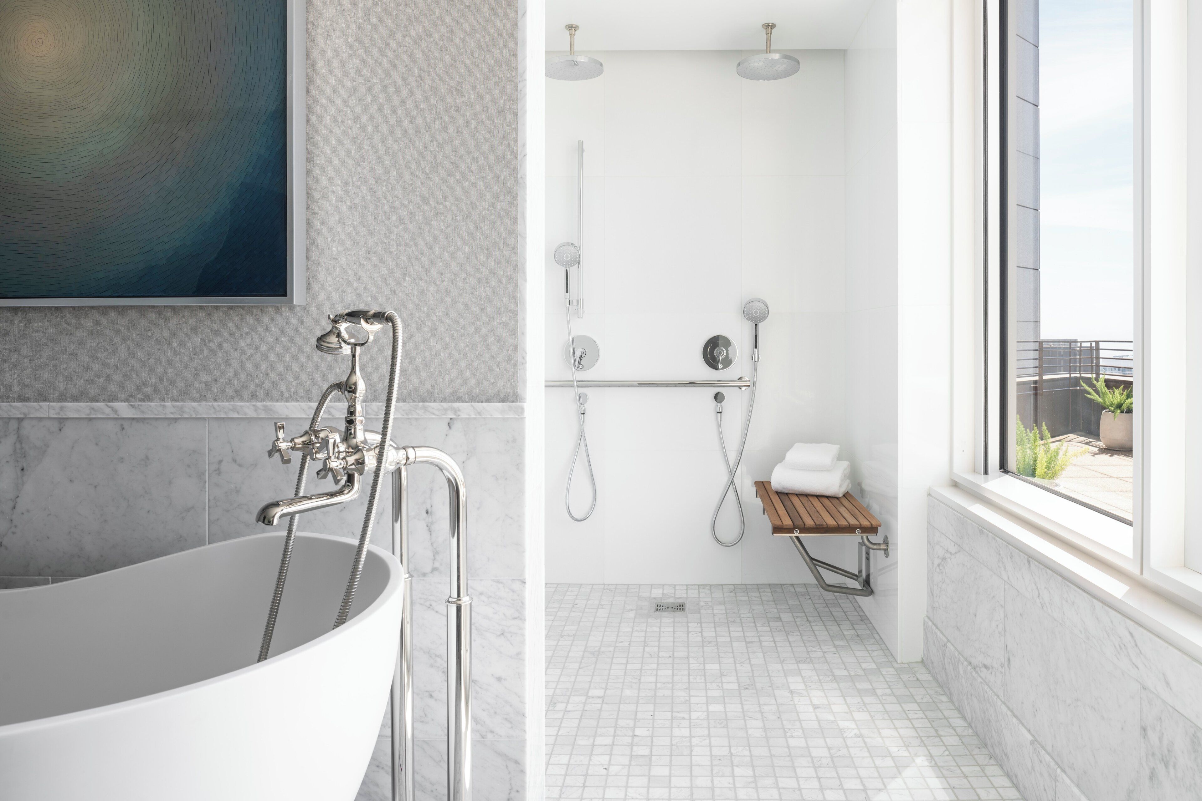 A modern bathroom with a freestanding bathtub, a shower with a glass enclosure, and a small wooden bench.