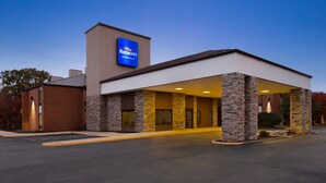 A modern hotel with a prominent Baymont sign, a covered entrance, and a parking lot.