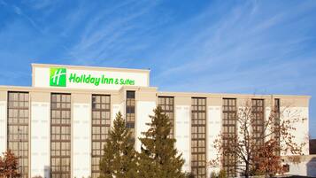 A Holiday Inn & Suites building with a clear sky.
