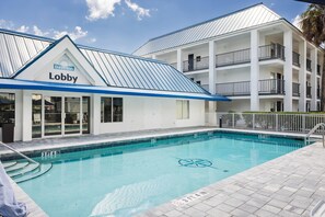 A Days Inn lobby with a pool area, including a pool with a lifeguard chair and a sign indicating a 3ft 4in depth. - Days Inn by Wyndham Port Charlotte/Punta Gorda (Port Charlotte)