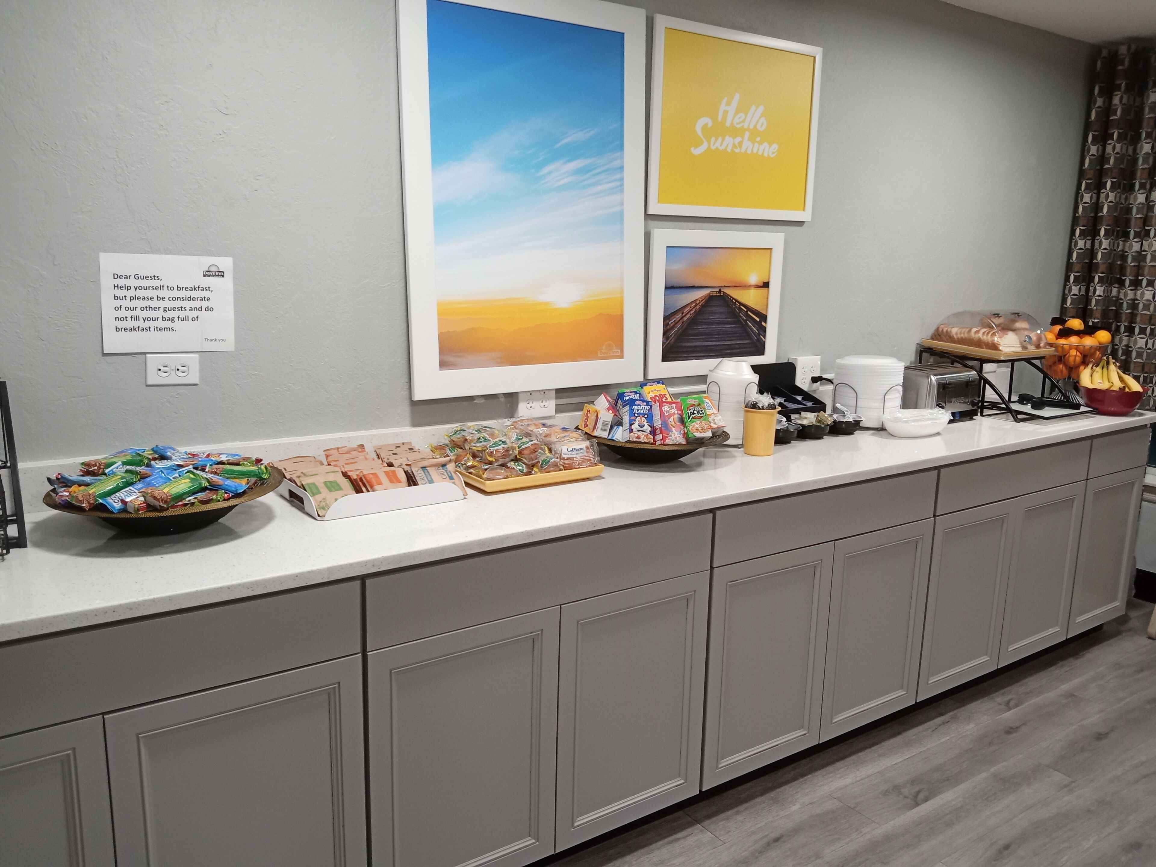 Disposição de buffet de café da manhã com diversos alimentos e um aviso aos hóspedes para que considerem os demais.