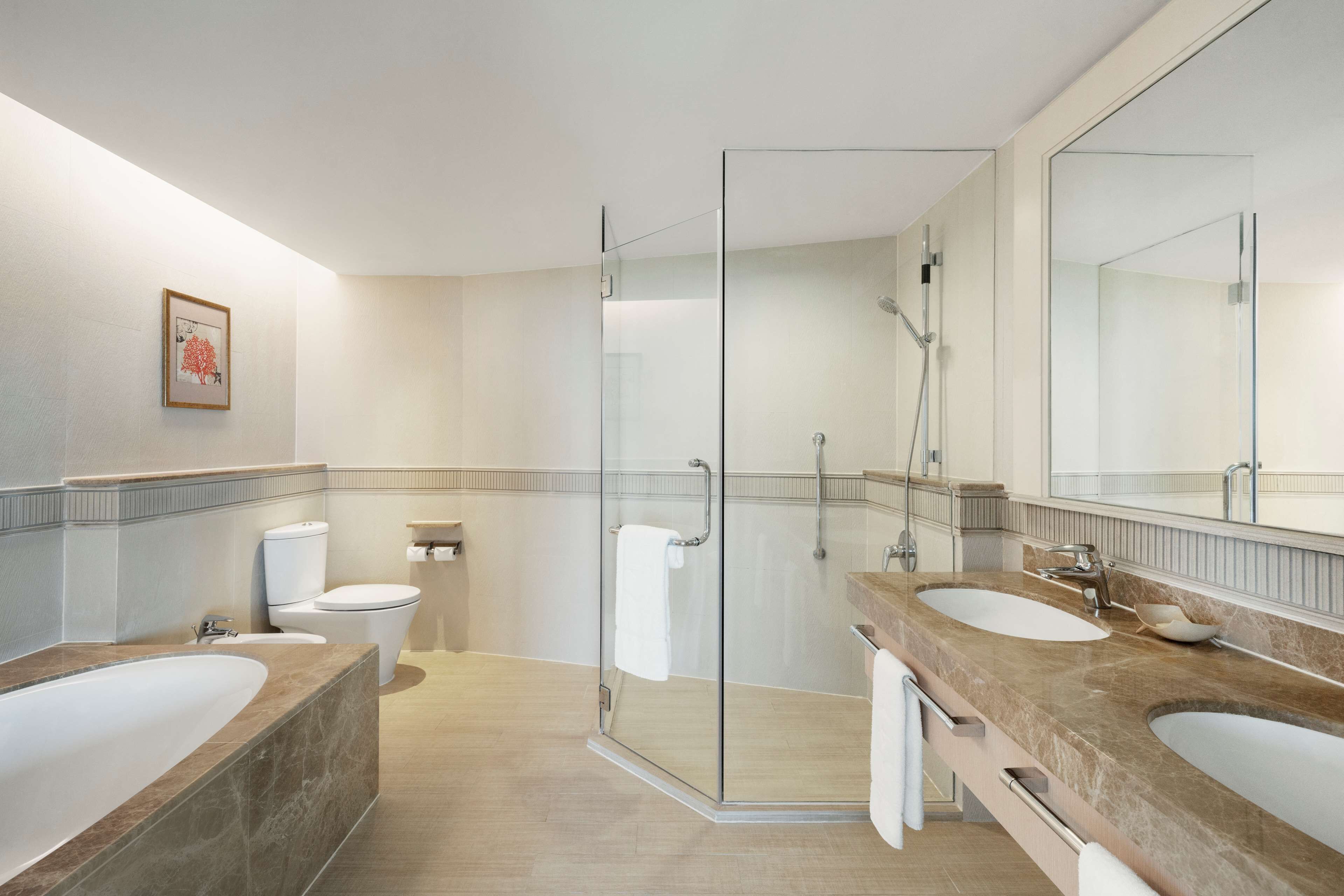 Ein modernes Badezimmer mit einer Duschkabine aus Glas, zwei Waschbecken und einem großen Spiegel.