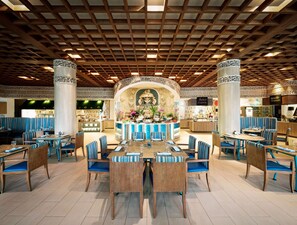 Um restaurante amplo com tetos de madeira alta e assentos listrados em azul.