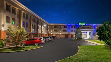 A Holiday Inn Express hotel with a parking lot, a Christmas tree, and a clear night sky.