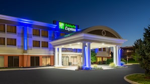 A Holiday Inn Express building with a covered entrance, columns, and a well-lit facade. - Holiday Inn Express Philadelphia NE - Bensalem by IHG (Bensalem)