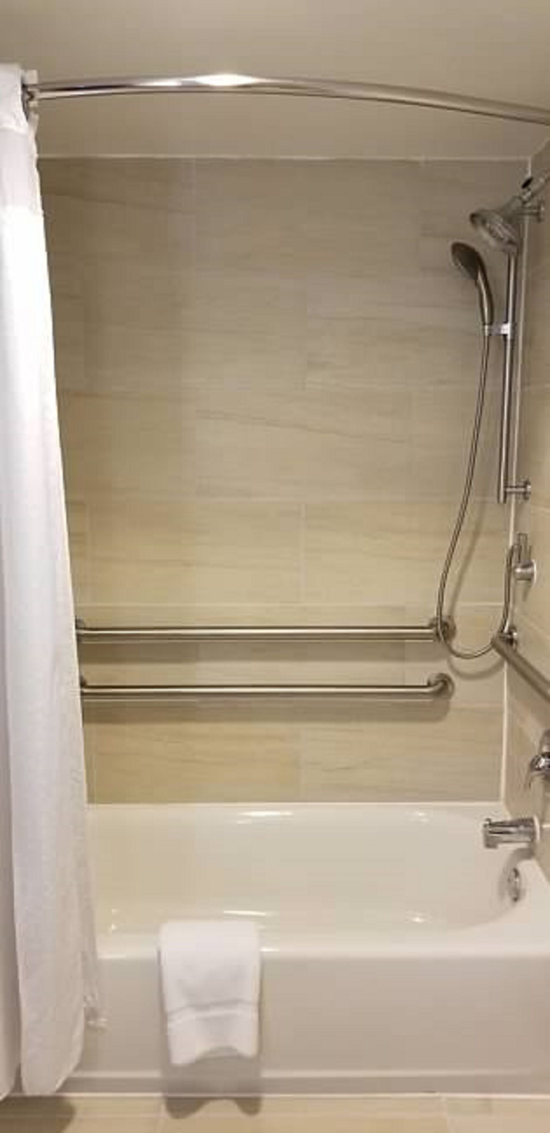 Un baño moderno con bañera, ducha y barra para toallas.