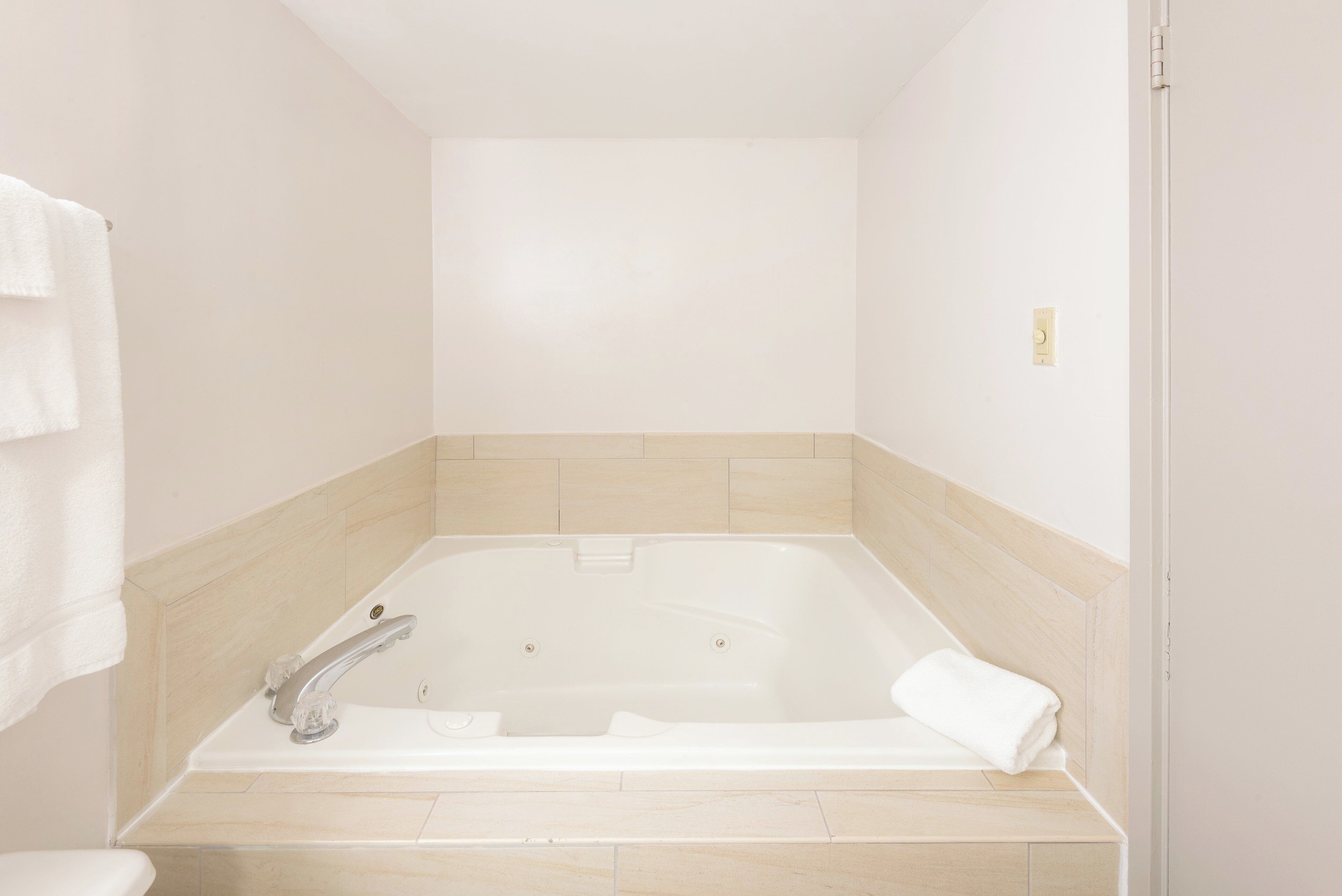 A bathroom with a bathtub, a toilet, and a towel rack.