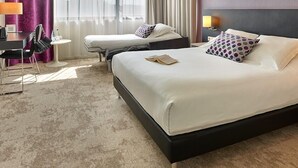 A hotel room with two beds, a desk, a chair, and a small table. - Best Western Plus Hotel Metz Technopole (Metz)