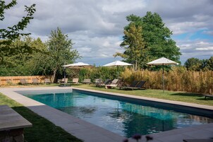 Una piscina al aire libre de temporada, sillones reclinables de piscina