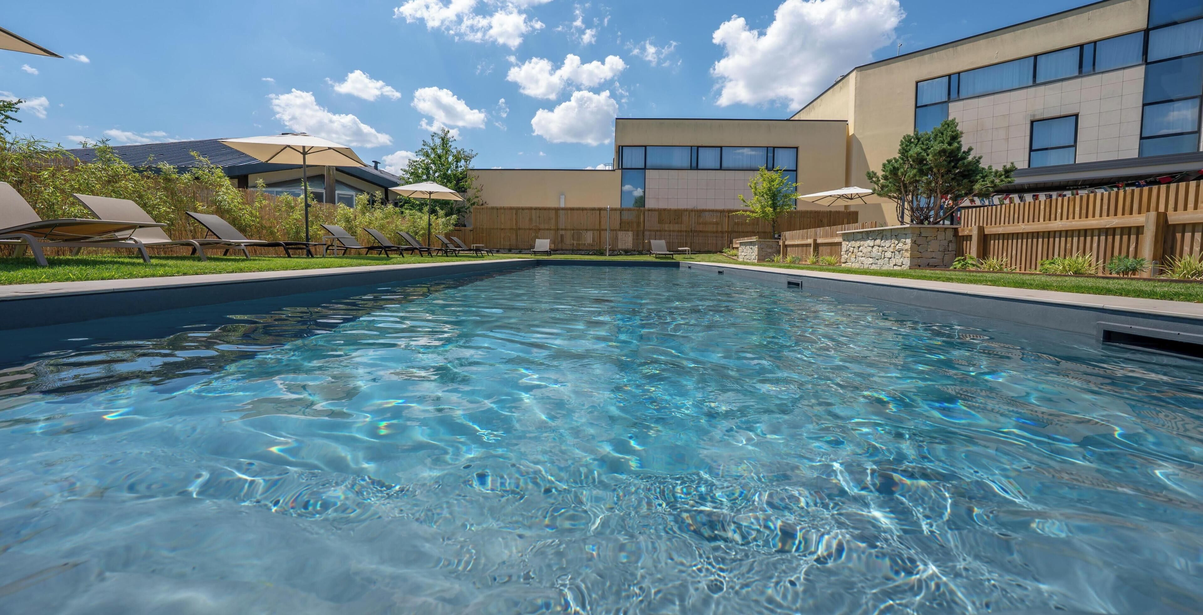 Una piscina al aire libre de temporada, sillones reclinables de piscina