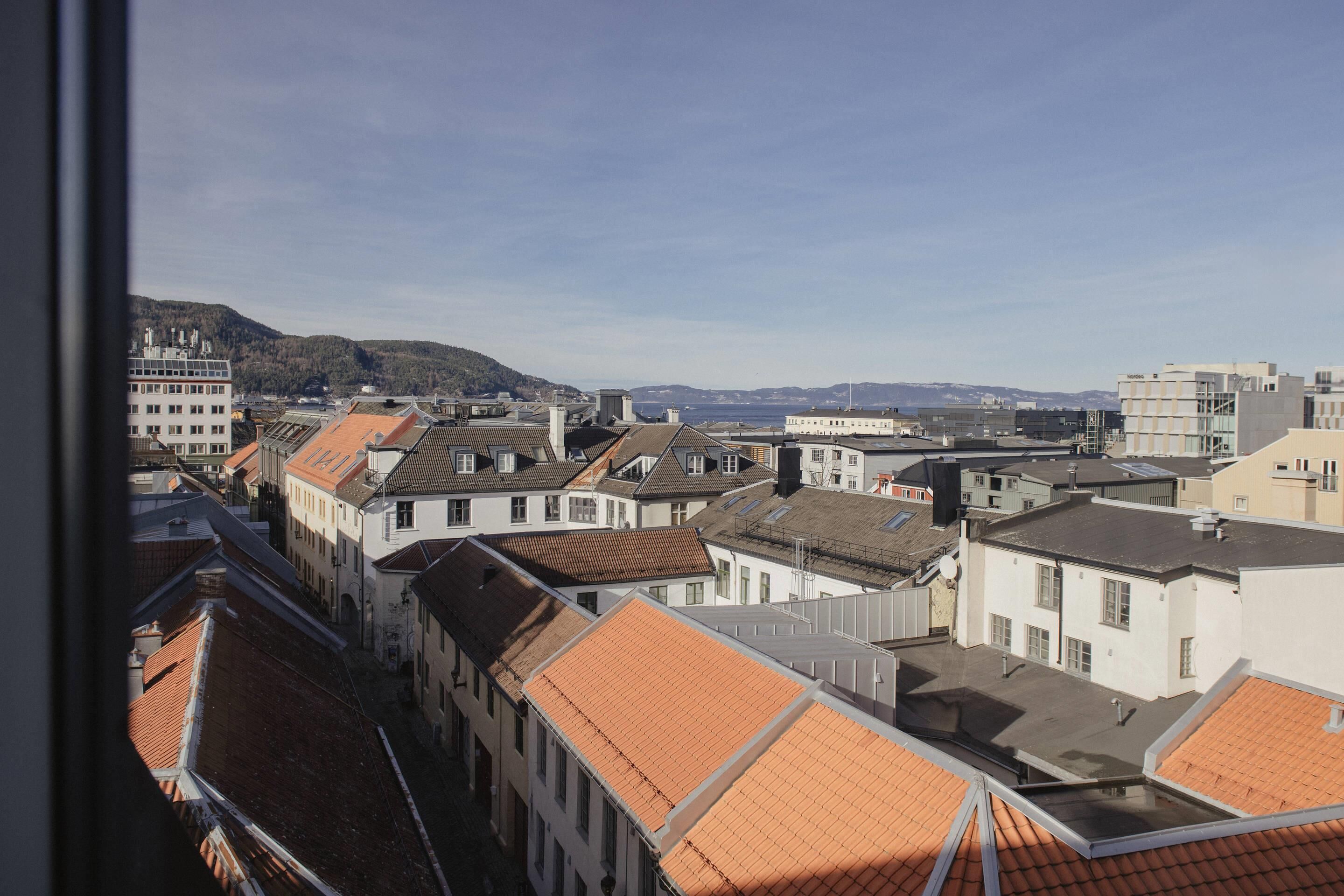 Un paisaje urbano con edificios que presentan techos de tejas rojas y una mezcla de estilos arquitectónicos.