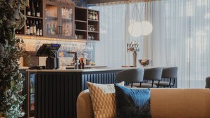 Zona de bar con mostrador, asientos y una planta decorativa.