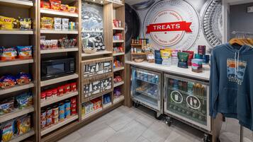 A snack and treat section with shelves stocked with various snacks, a refrigerated display, and a microwave.