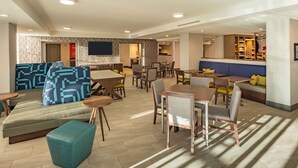 A modern hotel lobby with seating areas, a bar, and a flat-screen TV. - Hampton Inn Asheville-Tunnel Rd. (Asheville)