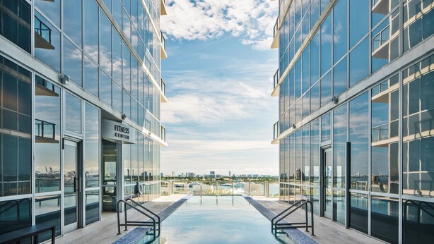 A modern building with a glass facade, a rooftop pool, and a view of the city skyline. - The Grayson Miami Downtown (Miami)