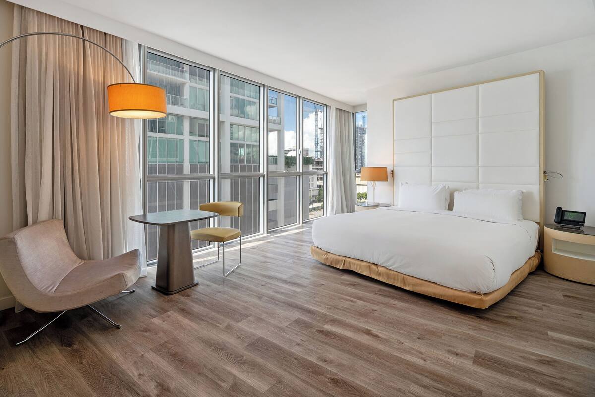Een moderne hotelkamer met een groot bed, een bureau en een stoel.