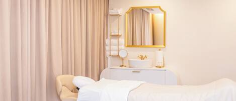 A hotel room with two beds, a vanity with a mirror, a white dresser, and a chair.