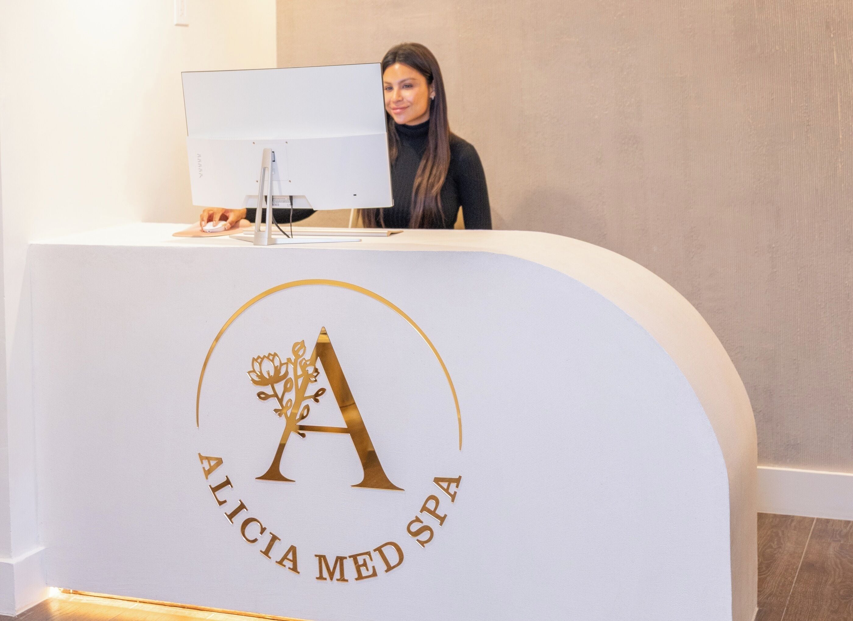 A reception desk with a logo that reads "Alicia Med Spa".