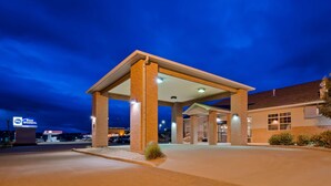 A gas station with a covered canopy, multiple fuel pumps, and a building with large windows. - Best Western Rambler (Walsenburg)