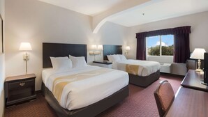 A hotel room with two beds, a desk, and a window with curtains. - Quality Inn Grand Suites Bellingham (Bellingham)