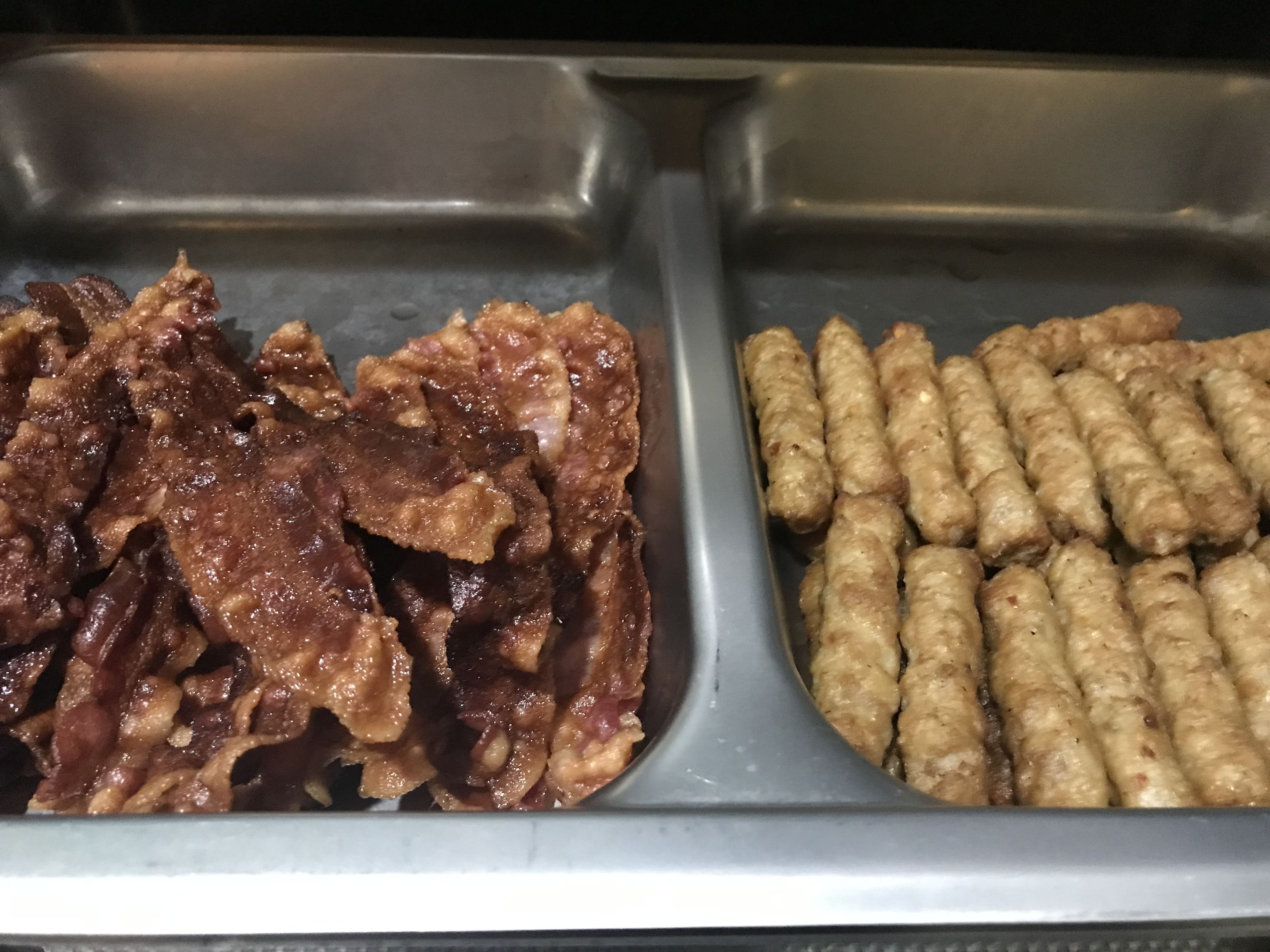 Un bufé con diversos alimentos, incluyendo carne en rodajas y salchichas.