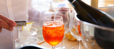 A person pouring a drink into a glass with ice cubes.
