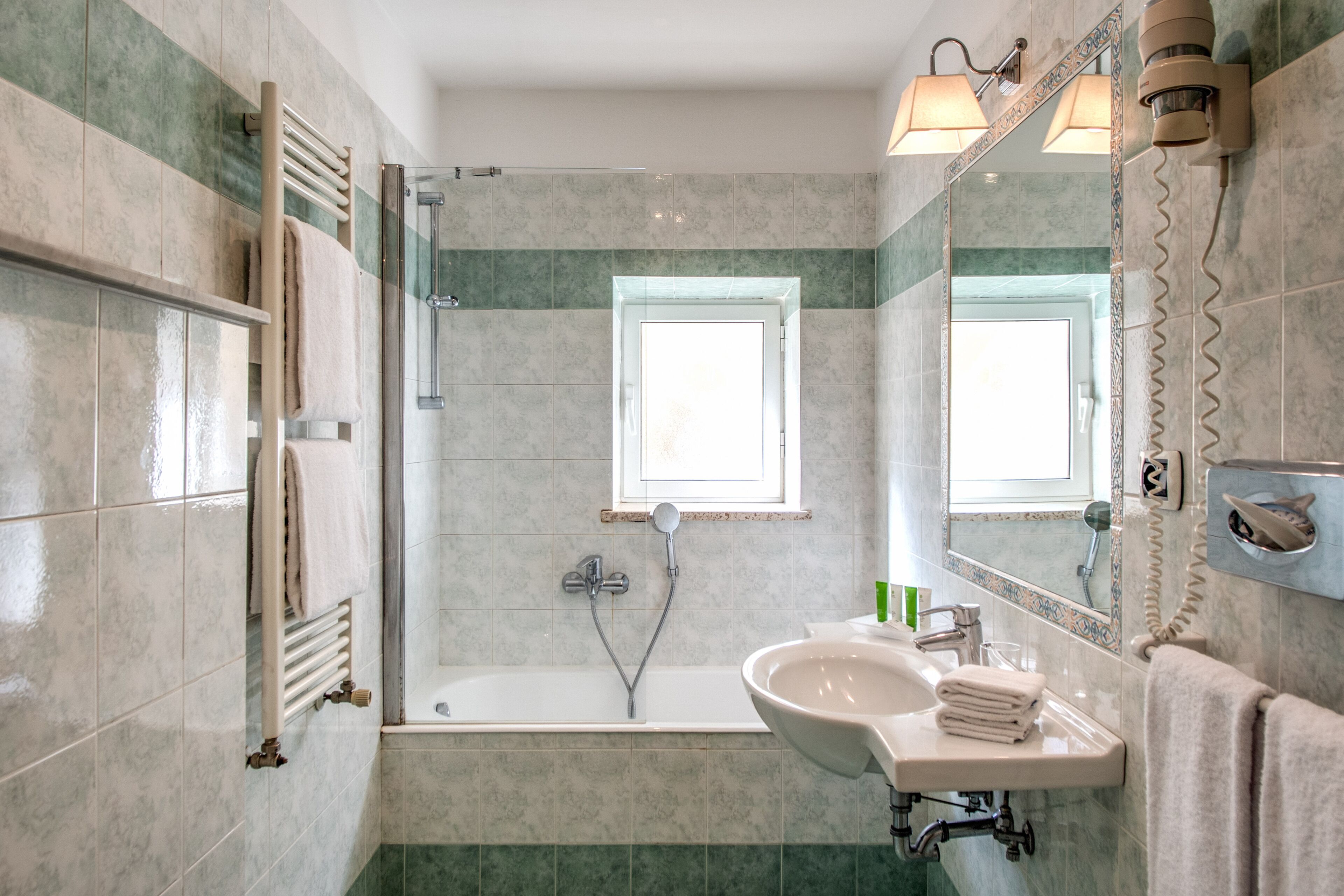 A bathroom with a bathtub, a sink, and a mirror.