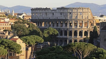 A historic building with multiple arches and columns, surrounded by trees and other buildings.