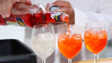 Una persona versa un liquido rosso in tre bicchieri, due dei quali sono pieni di ghiaccio.