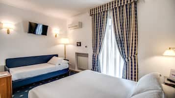 Una camera d'albergo con un letto grande, un letto più piccolo, una TV e due lampade da comodino.