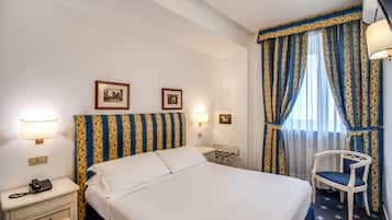 Una camera d'albergo con un letto, comodini, una sedia e tende.