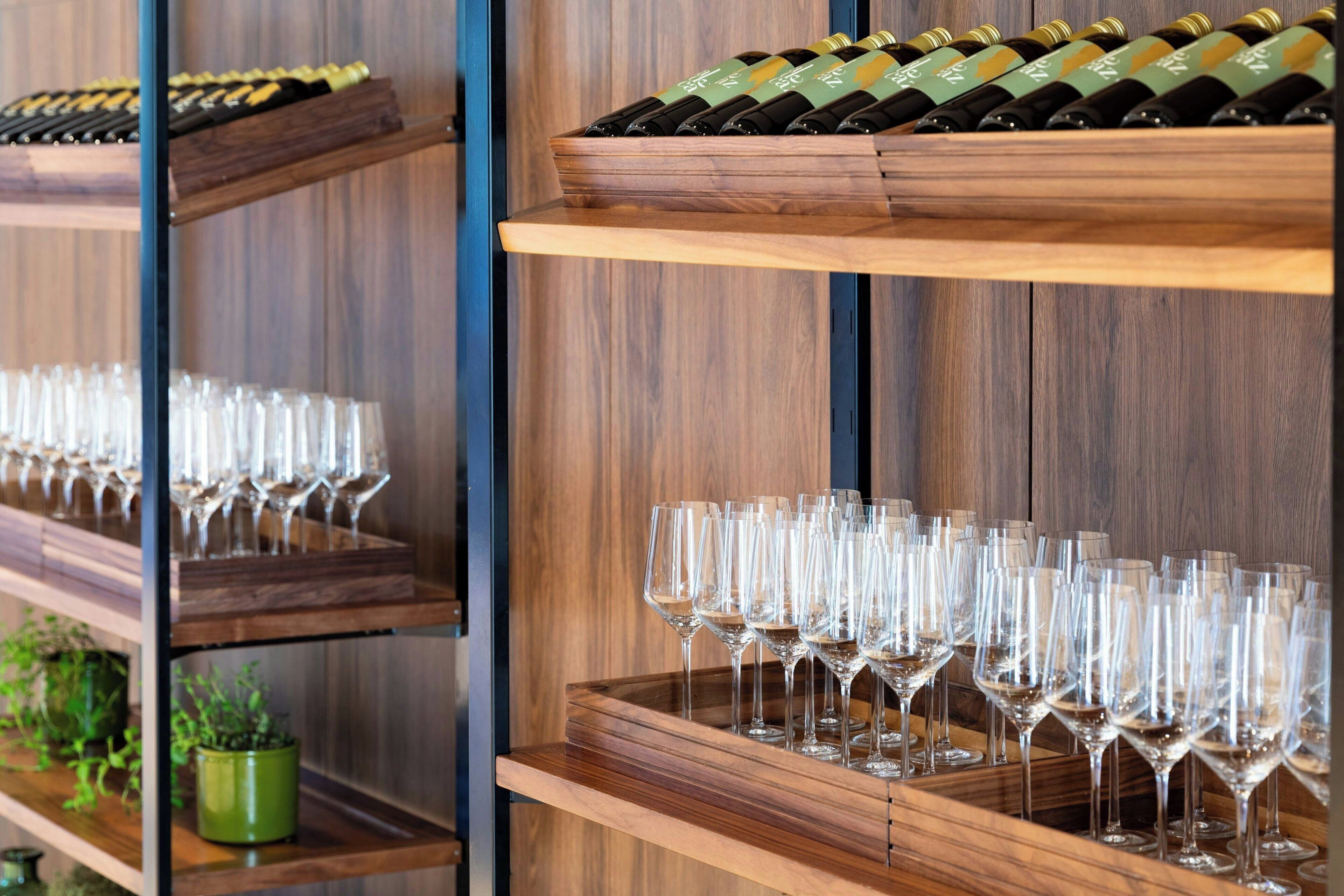 Una estantería para vinos con botellas y copas.